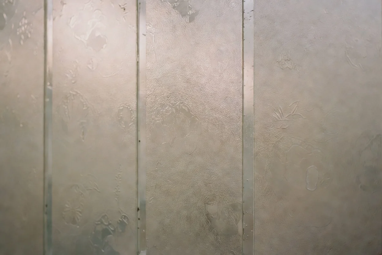 Translucent patterned and frosted glass panels filtering soft daylight in a modern bathroom